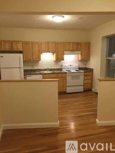 A kitchen with wooden cabinets and a white refrigerator.