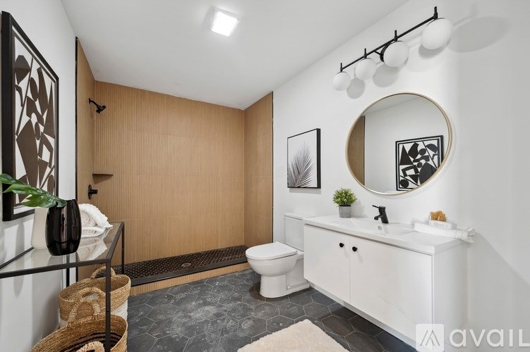 A bathroom with a toilet, sink, mirror, and a plant.