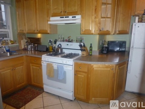 A kitchen with wooden cabinets and a white stove top oven.