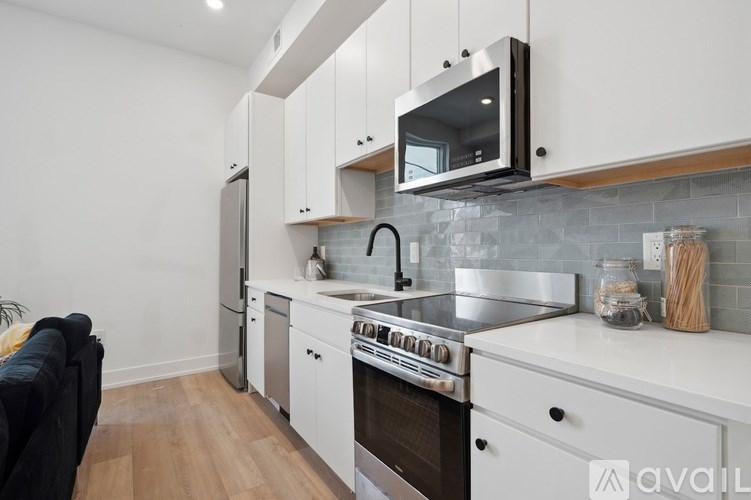 A modern kitchen with white cabinets and stainless steel appliances.