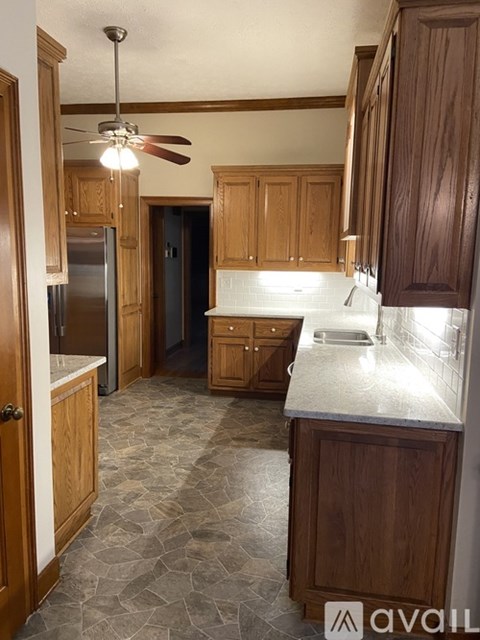A kitchen with wooden cabinets and a marble countertop.