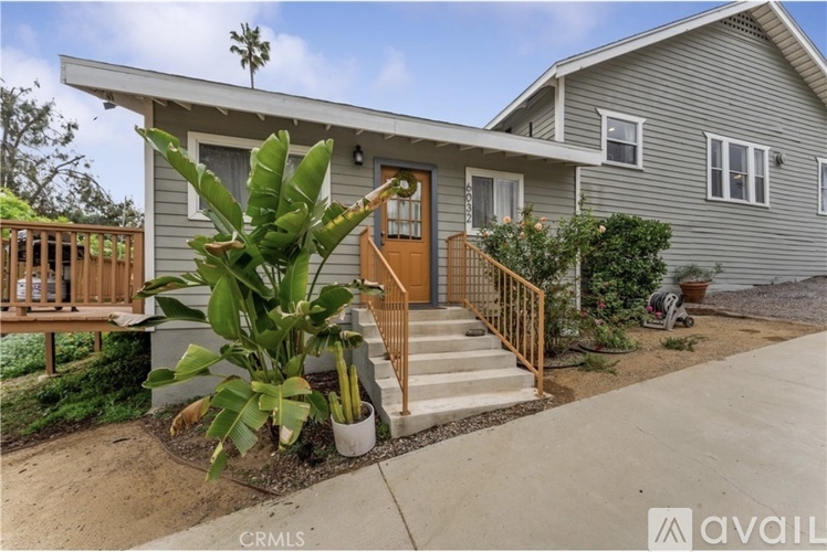 A house with a wooden front door and steps leading to the entrance.