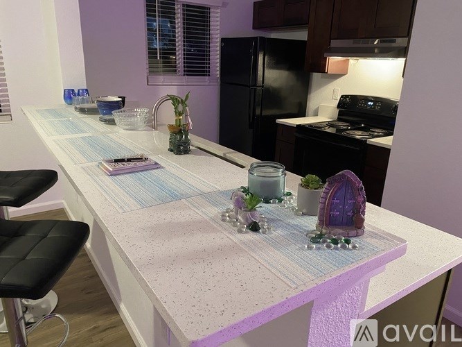 A kitchen with a table and chairs.