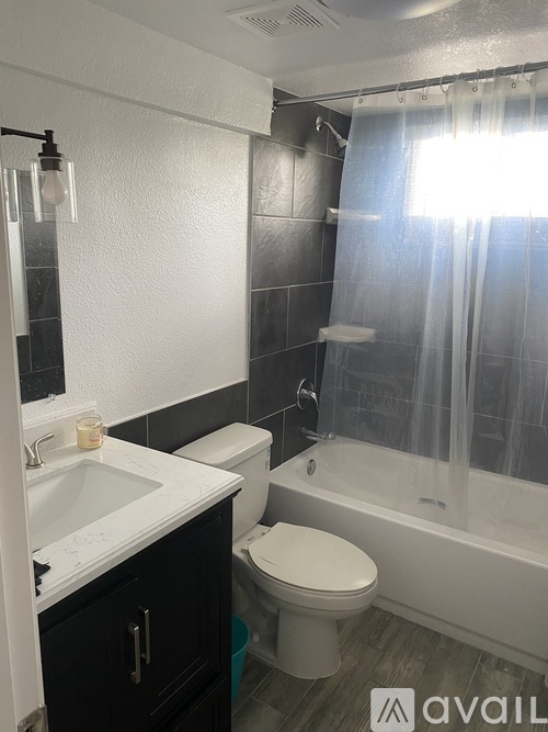 A bathroom with a toilet, sink, and bathtub.