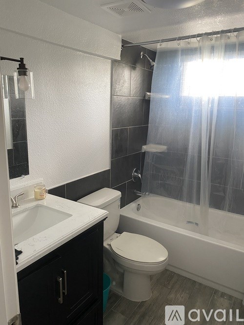 A bathroom with a toilet, sink, and bathtub.