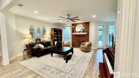 A living room with a dark brown couch and a rug.