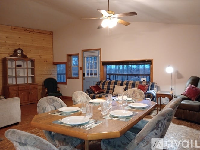 A dining room with a wooden table set for a meal.