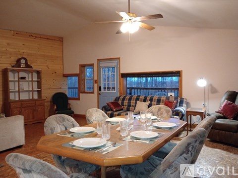 A dining room with a wooden table set for a meal.