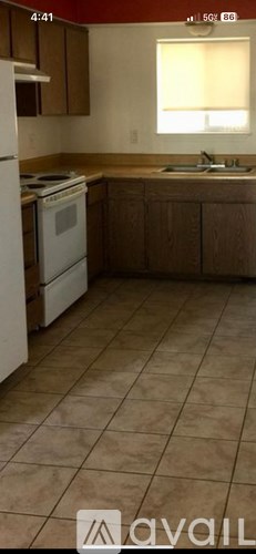 A kitchen with a white stove and brown cabinets.