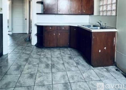 A kitchen with brown cabinets and a white sink.