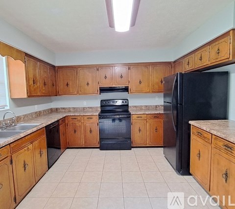 A kitchen with wooden cabinets and black appliances.