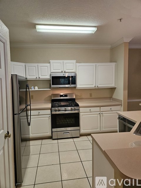 A kitchen with white cabinets and appliances.