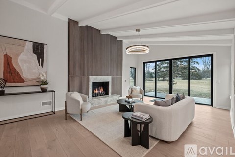 A modern living room with a fireplace and a large painting on the wall.