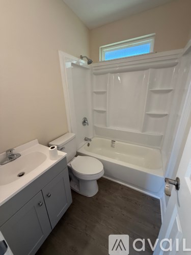 A bathroom with a toilet, sink, and bathtub.