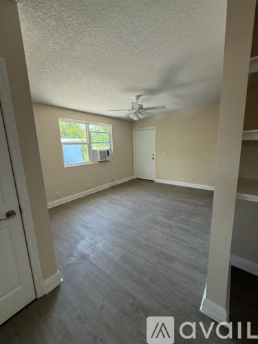 A room with a ceiling fan and a window with blinds.