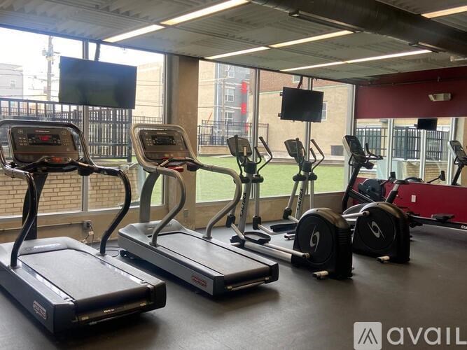 A gym with treadmills, elliptical machines and a television.