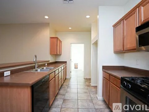 A kitchen with wooden cabinets and black appliances.