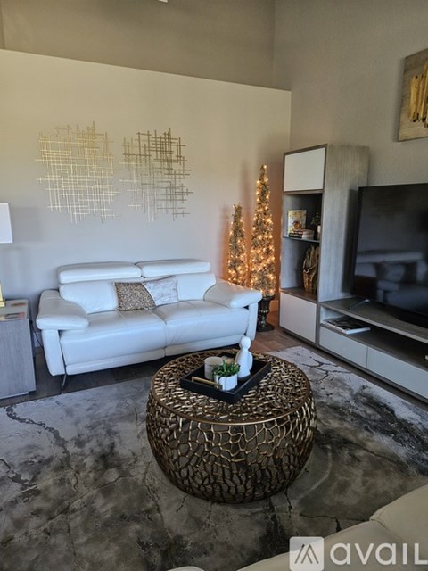 A living room with a white couch and a glass coffee table.