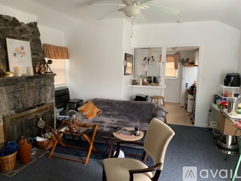 A living room with a grey couch and a wooden chair.