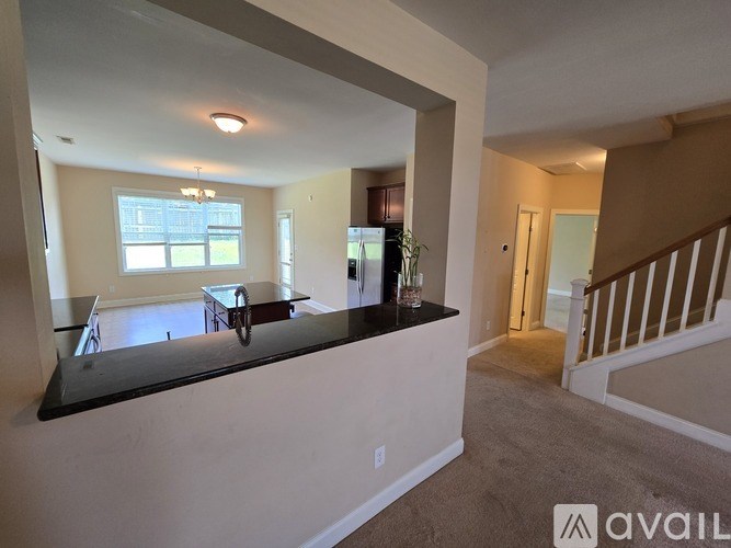 A spacious living room with a black countertop and a staircase on the right.