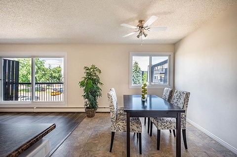A dining room with a table and chairs.