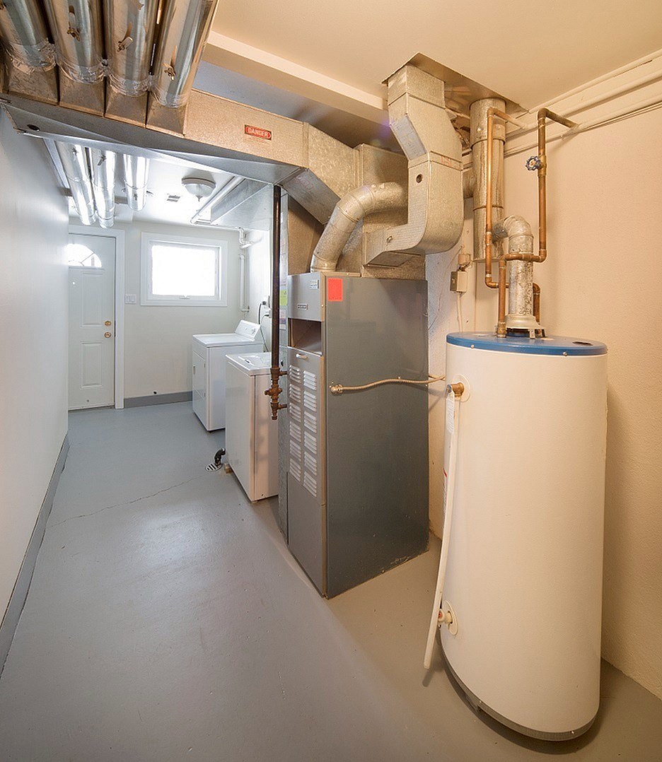 A room with a white tank and a grey floor.