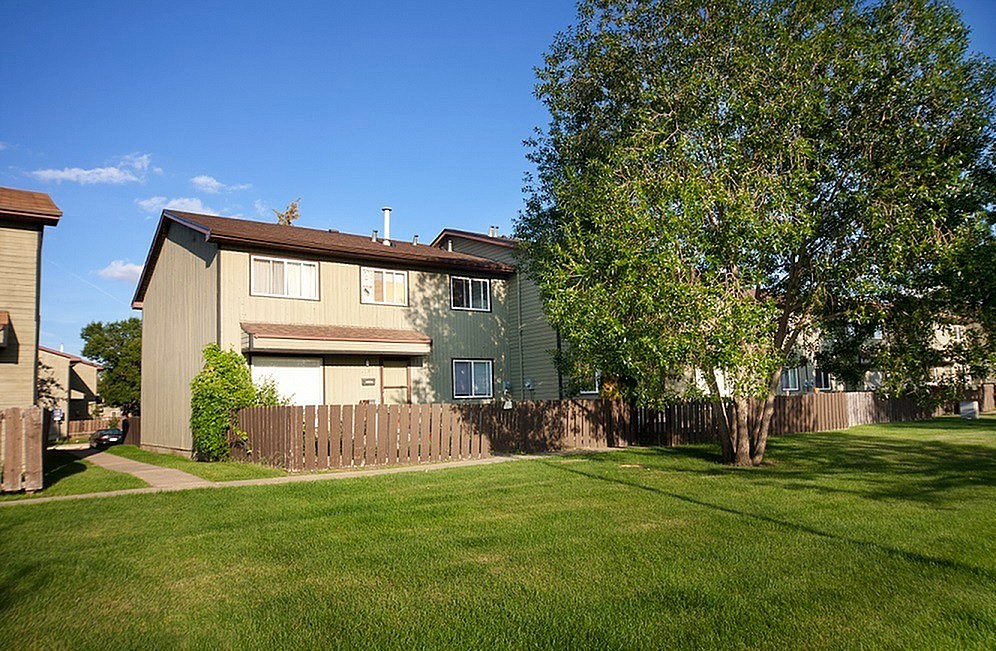 A house with a green tree in front of it.