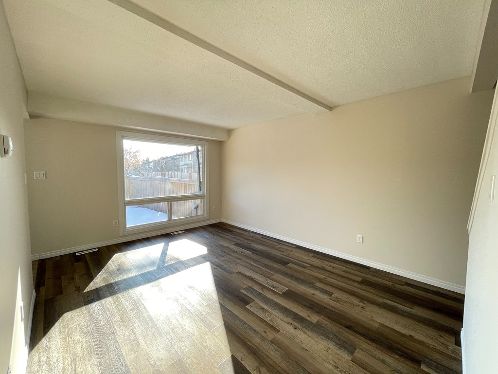 A room with wooden floors and a window.
