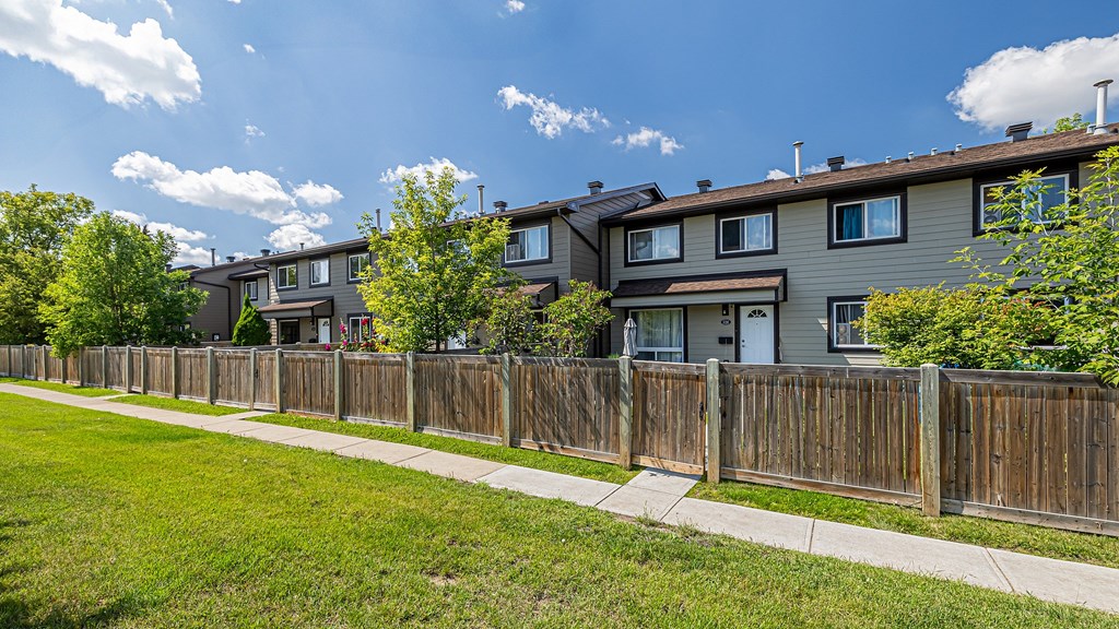 A row of houses with a wooden fence in front.