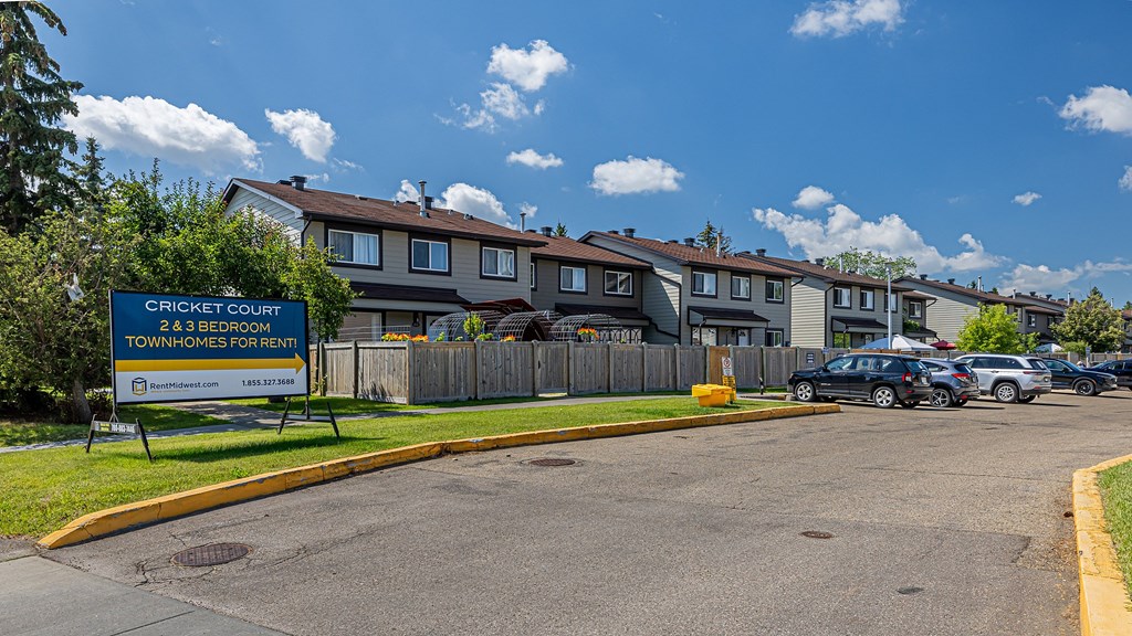 A sign in front of a building advertises that the townhomes are for rent.