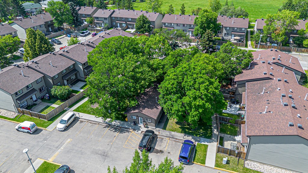 A parking lot with cars and a building with a red roof.
