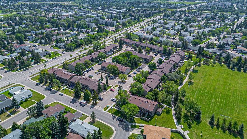 A bird's eye view of a residential area with houses and green lawns.