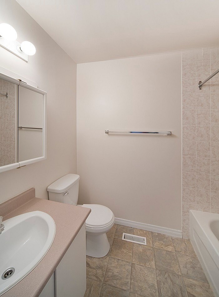 A bathroom with a toilet, sink, and bathtub.