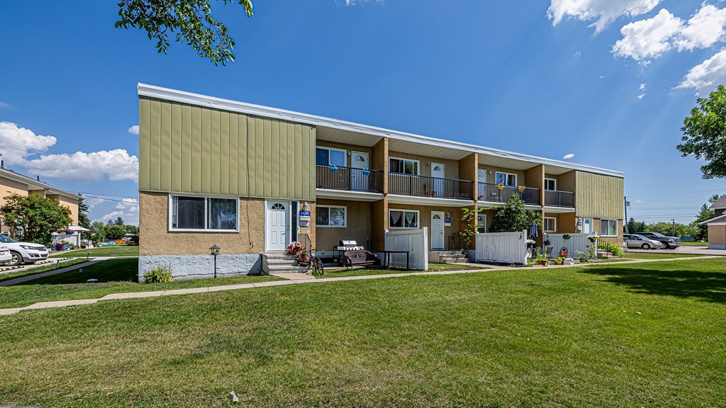 A building with a green roof and a white fence in front.