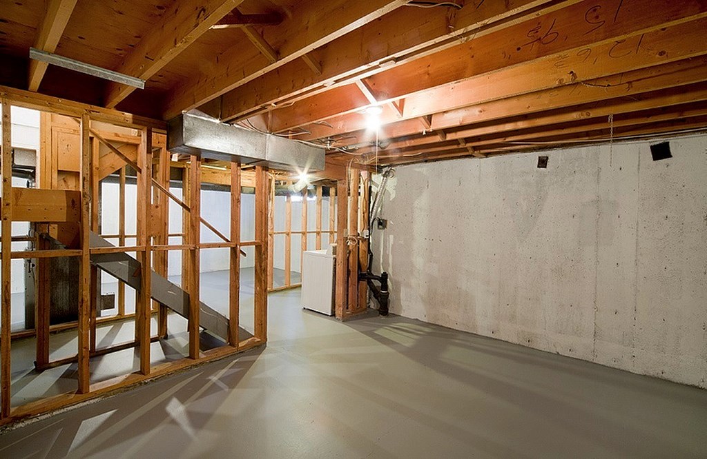 A room under construction with wooden beams and concrete walls.