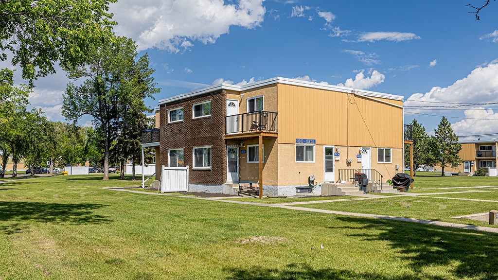 A two-story apartment building with a balcony on the second floor.