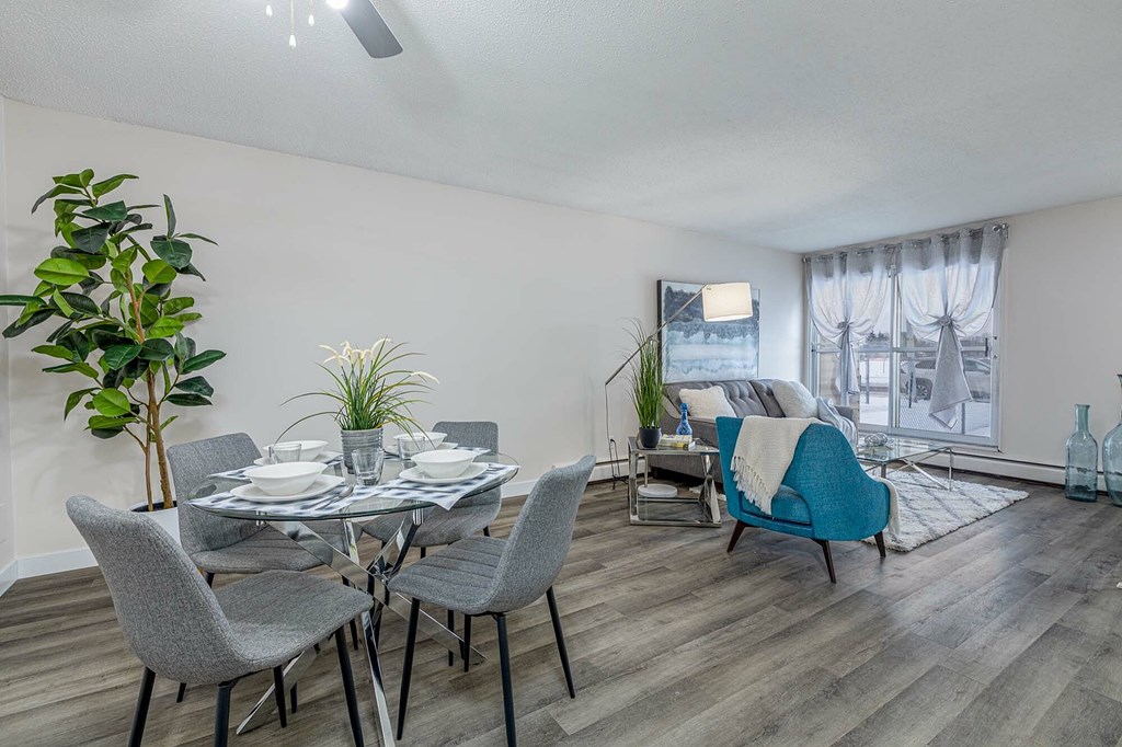 A dining room with a table set for four and a blue chair.