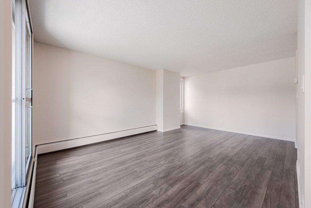A room with wooden flooring and white walls.