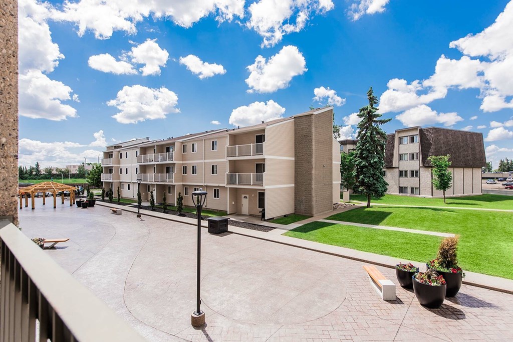 A courtyard with a bench and a lamp post in the middle.