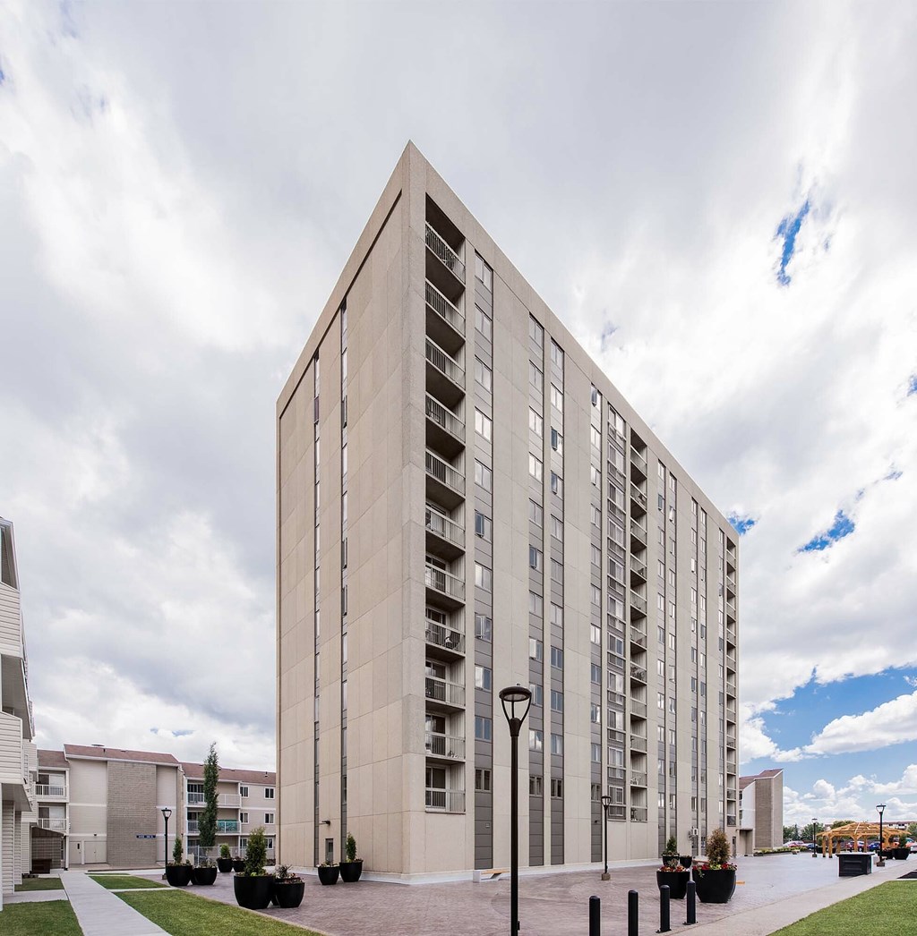 A tall building with a flat roof and a series of windows on each floor.