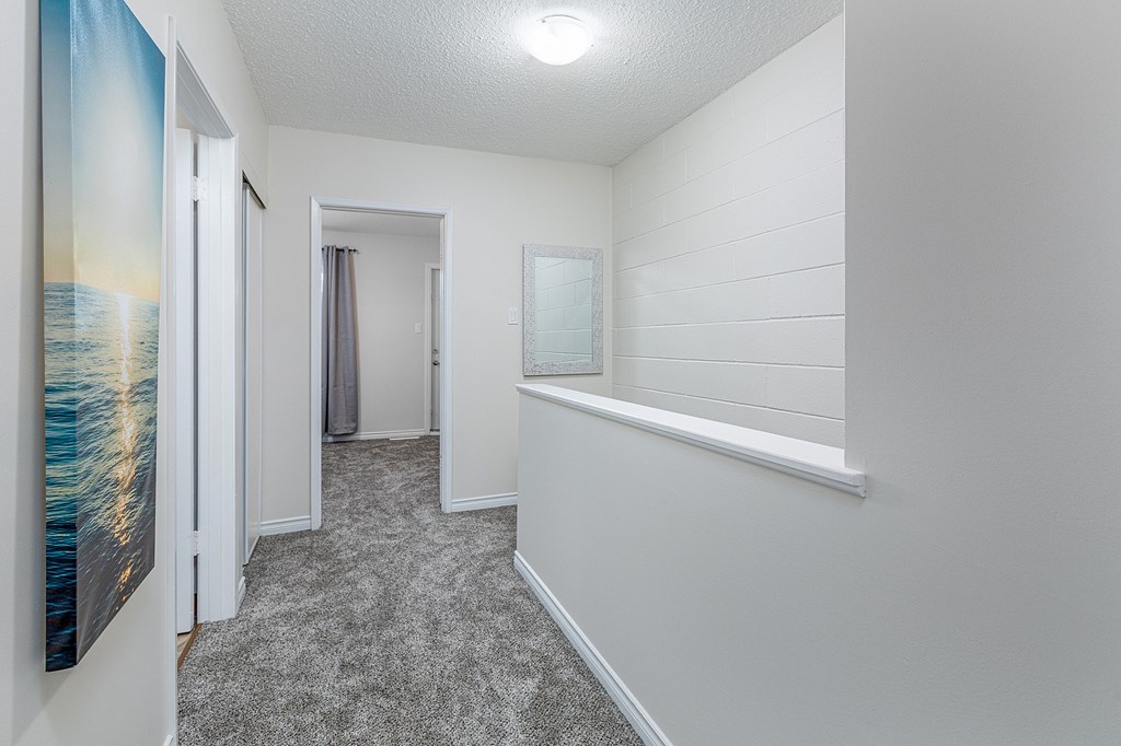 A hallway with a painting of a beach on the wall.