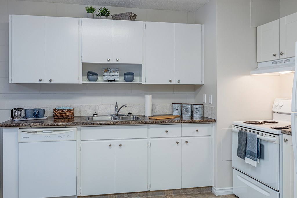 A kitchen with white cabinets and appliances.