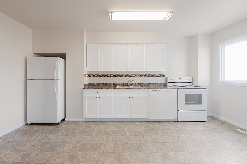 A kitchen with white appliances and cabinets.