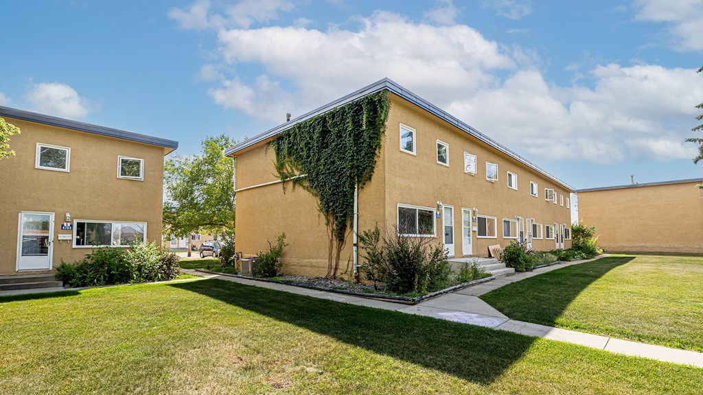 A building with a green plant on the side.