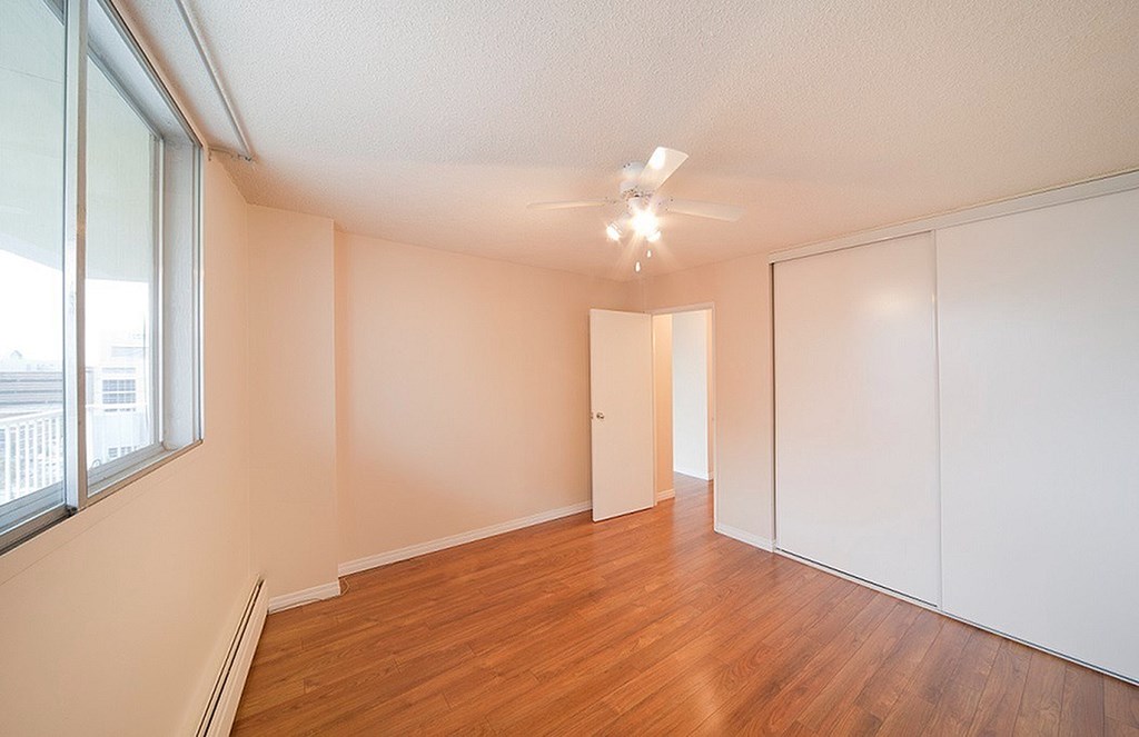 A room with a ceiling fan and a window.