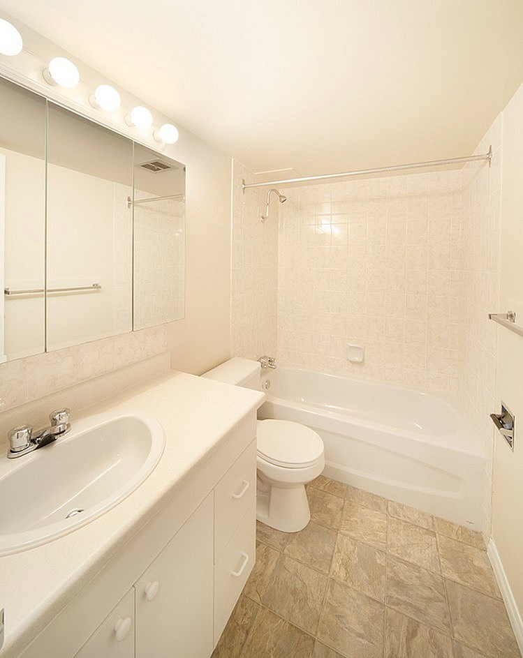 A white bathroom with a toilet, sink, and bathtub.