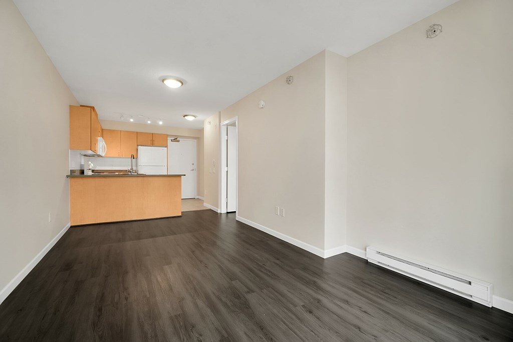A kitchen with wooden floors and white walls.