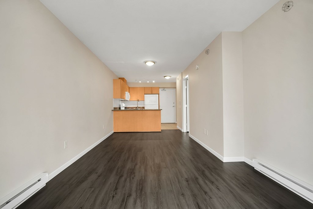 A long hallway with a kitchen area at the end.