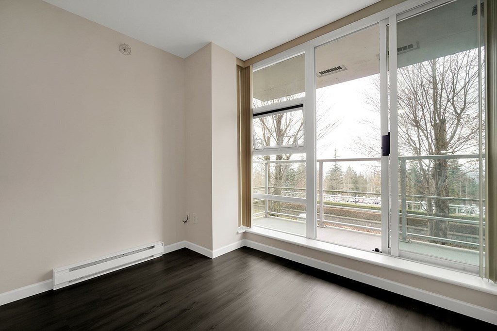 A room with a large window and a white radiator on the wall.