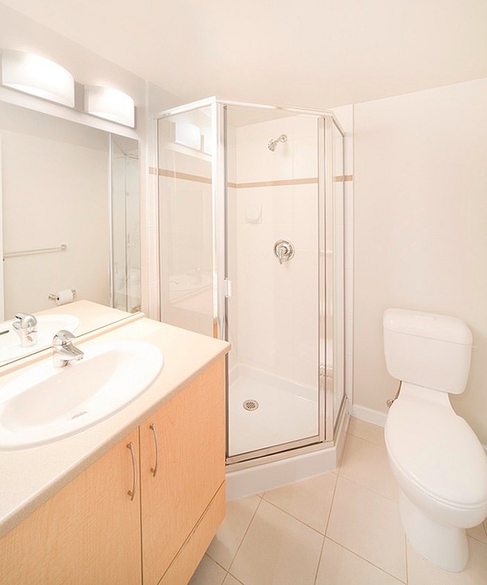 A white toilet sits next to a sink in a bathroom.